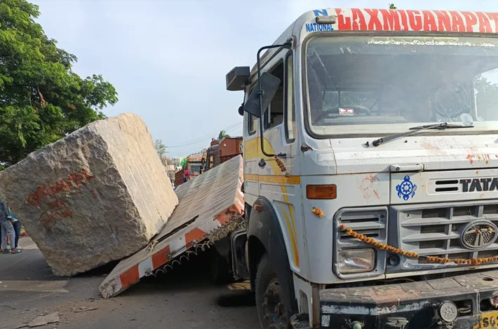 లారీ పై నుండి రోడ్డుపై పడిన గ్రానైట్ బండ